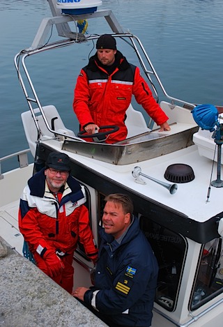 På väg ut med kustbevakningens båt ser vi Jesper Larsson (uppe), Mats Persson (t h) och deras f.d. chef Claes Löwdahl.